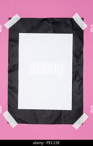 top view of empty white paper on black crumpled paper on pink Stock Photo