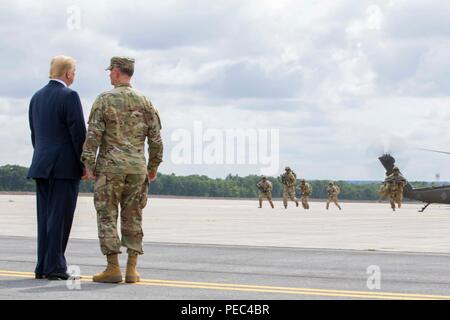 President Donald J. Trump and Maj. Gen. Walter E. Piatt, commander of the 10th Mountain Division (LI), view an air assault and gun raid demonstration at Fort Drum, New York, on August 13. The demonstration was part of President Trump's visit to the 10th Mountain Division (LI) to sign the National Defense Authorization Act of 2019, which increases the Army's authorized active-duty end strength by 4,000 enabling us to field critical capabilities in support of the National Defense Strategy. (U.S. Army photo by Sgt. Thomas Scaggs) 180813-A-TZ475-008 Stock Photo