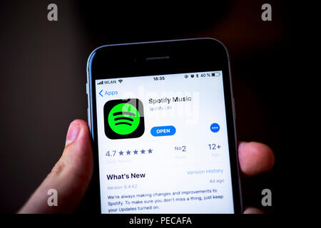 Hand holding iPhone, Spotify Music App in the Apple App Store, music streaming service, app icon, iPhone, iOS, smartphone Stock Photo