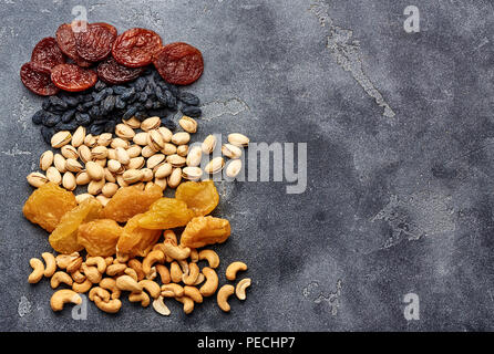 Mix dried fruits and nuts on gray background. Top view of superfoods. Stock Photo