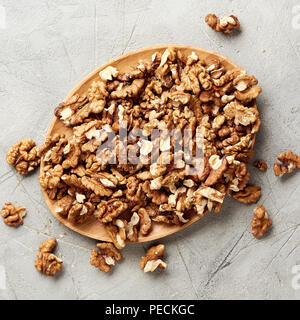 Walnut kernels on gray background and nutcracker. Stock Photo