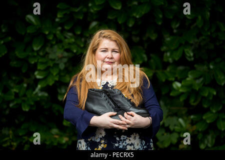 Cat Wilkinson, daughter of Michael Gallagher, outside the offices of Omagh Support & Self Help Group, holding her brother Aiden's work boots, which he bought on the day of the Omagh bomb. Aiden Gallagher, who was killed in the bomb, had been preparing to emigrate to the United States, his sister has revealed. Stock Photo