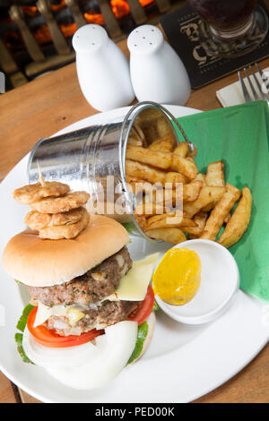 Homemade double hamburger and cheese with a bucket/pail of potato chips/fries and English mustard Stock Photo