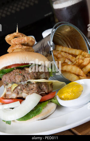 Homemade double hamburger and cheese with a bucket/pail of potato chips/fries and English mustard Stock Photo