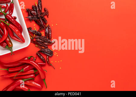 Groups of red chilli peppers and dried chinese hot capsicum isolated on the red background Stock Photo