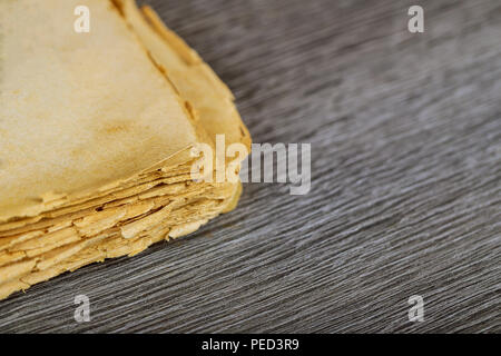 Opened destroyed blank pages of old book on wood background Stock Photo