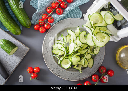 spiralizing cucumber vegetable with spiralizer Stock Photo