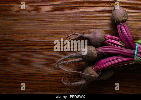 Red organic bunch Beetroot with herbage green leaves with foliage, on wooden background Stock Photo