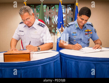 U.S. Air Force Maj. Gen. Abel Barrientes (left), Pacific Air Forces vice commander's individual mobility assistant, and Bangladesh Air Force Air Commodore Hasan Khan (right), Bangladesh Air Force plans director, conclude the Airman-to-Airman Talks, by signing the minutes, Joint Base Pearl Harbor-Hickam, Hawaii, Aug. 6, 2015. The aim of the inaugural U.S. and Bangladesh Airman-to-Airman Talks was to bolster an earnest relationship between key leaders and pave the way for future cooperation among the two air forces. Discussion topics focused on a number of key matters which will enable both coun Stock Photo
