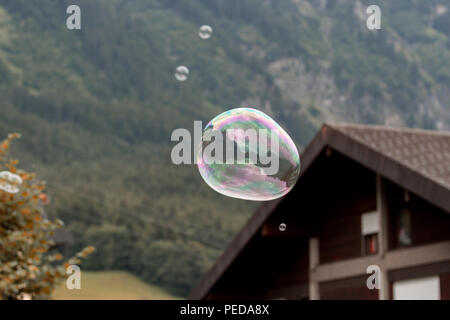 Big soap bubble flying through the air in the mountains Stock Photo