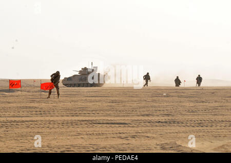 Engineers assigned to 588th Brigade Engineer Battalion, 3rd Armored Brigade Combat Team, 4th Infantry Division, dismount a M2 Bradley Fighting Vehicle and mark a breach for maneuvering units during a live fire exercise at Udairi Range Complex, Aug. 4, 2015.  The breach is the essence of combined arms warfare and helps to set the conditions for the maneuvering units to get to their objectives and complete the mission. (Photo by Spc. Gregory Summers, 3rd ABCT Public Affairs, 4th Inf. Div.) Stock Photo