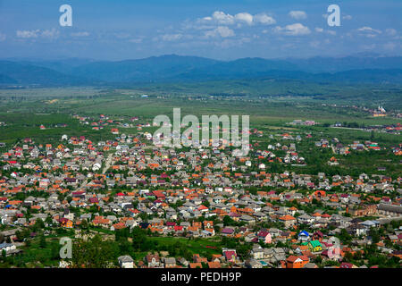 Colorful exalted view from a bird's eye view to houses in residential  district in the city of Khust, Western Ukraine with high mountains in the backg Stock Photo