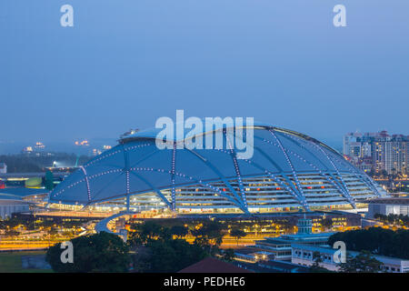 Architecture of Singapore sports hub stadium during magic hour in the evening. The massive huge roof top is partially lighted up. Stock Photo