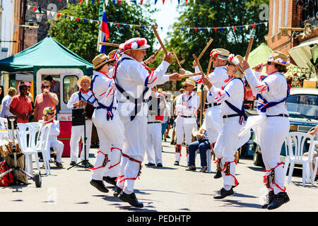 Traditional English folk dancers from the East Kent Morris side dancing in the street on a hot summer day during the Sandwich Folk and Ale Festival Stock Photo
