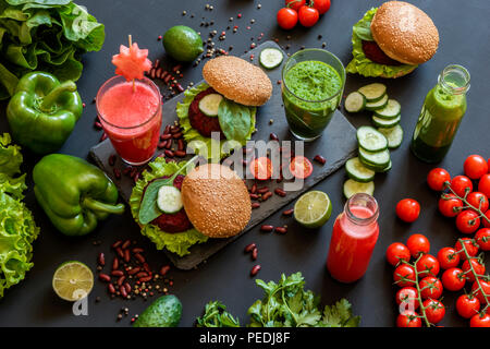 Healthy vegan food. Fresh vegetables on black background. Detox diet. Different colorful fresh juices. Stock Photo