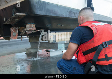 Petty Officer 3rd Class Tyler Bone, a crew member from Coast Guard Station St. Petersburg, Fla., conducts a post search-and-rescue boarding of a 32-foot boat at Hula Bay Marina, Tampa, Fla., Monday, Aug. 10, 2015. Bone and fellow crew members from the station rescued a couple and their two dogs after the boat began taking on water five miles south of the Gandy Bridge, in Tampa. (U.S. Coast Guard photo by Petty Officer 3rd Class Ashley J. Johnson) Stock Photo