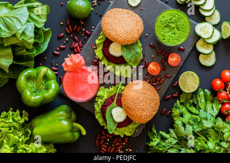 Healthy vegan food. Fresh vegetables on black background. Detox diet. Different colorful fresh juices. Flat lay Stock Photo