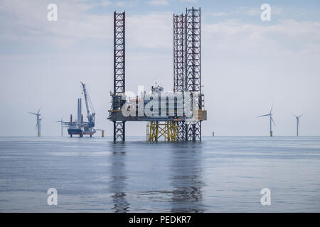 Atlantic Amsterdam jacked up adjacent to Offshore Substation (OSS) Z01 on Race Bank Offshore Wind Farm, UK. A2Sea's jack-up vessel, Sea Installer, is seen in the distance. Stock Photo