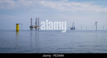 Atlantic Amsterdam jacked up adjacent to Offshore Substation (OSS) Z01 on Race Bank Offshore Wind Farm, UK. A2Sea's jack-up vessel, Sea Installer, is seen in the distance. Stock Photo