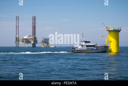 Seacat Mischief transferring workers onto Transition Piece E03 on the Race Bank Offshore Wind Farm in the Southern North Sea, UK. Atlantic Amsterdam is seen jacked up adjacent to Offshore Substation (OSS) Z01 in the distance. Stock Photo