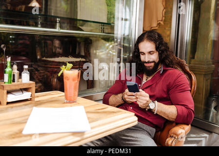 Delighted nice man using his smartphone Stock Photo