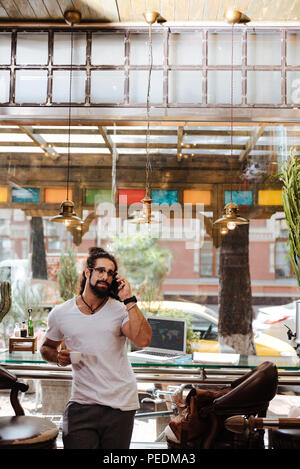 Positive bearded man talking on the phone Stock Photo