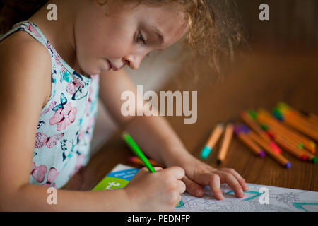 Young girl coloring in coloring in book Stock Photo