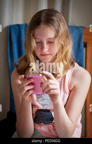 Girl playing on pink iphone Stock Photo