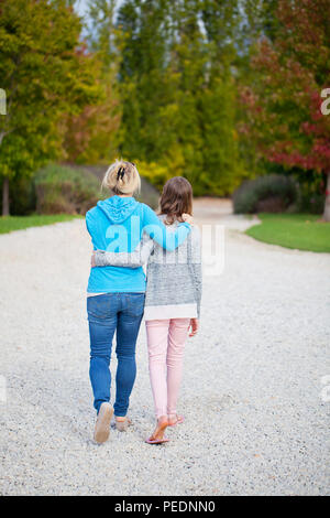 Mother daughter arm in arm walking Stock Photo