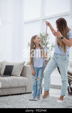 Young woman measuring her daughter's height at home Stock Photo