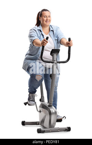 Overweight woman exercising on a stationary bike isolated on white