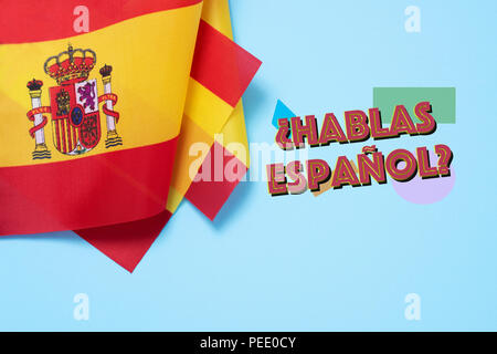 some flags of Spain and the question hablas espanol? do you speak Spanish? written in Spanish, on a blue background Stock Photo