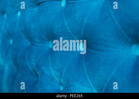 Velour surface of sofa close-up. Coach-type velours screed tightened with buttons. Blue chesterfield style quilted upholstery backdrop close up Stock Photo