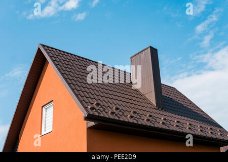 Modern roof covered with tile effect PVC coated brown metal roof sheets Stock Photo