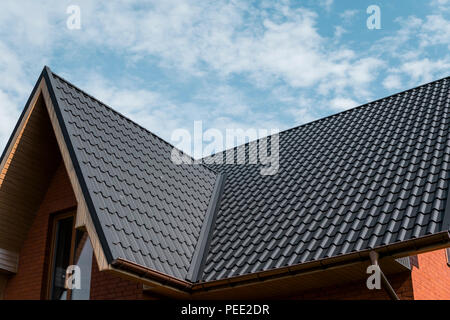 Modern roof covered with tile effect PVC coated brown metal roof sheets Stock Photo