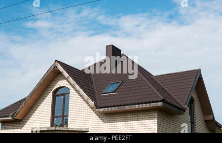 Modern roof covered with tile effect PVC coated brown metal roof sheets Stock Photo