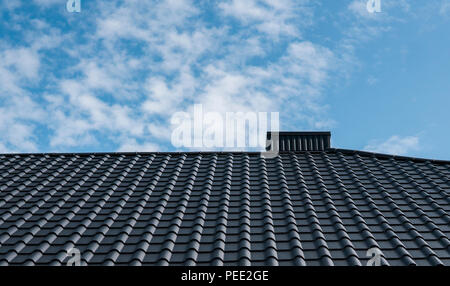 Modern roof covered with tile effect PVC coated brown metal roof sheets Stock Photo