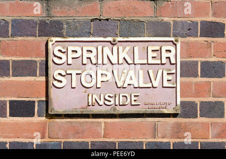 Old Mather & Platt fire safety sign saying 'sprinkler stop valve inside' on wall of old factory in Digbeth, Birmingham Stock Photo