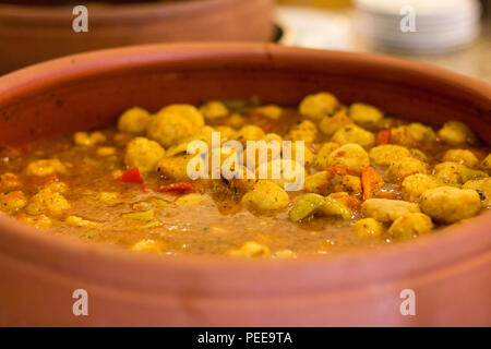 Stewed potatoes with vegetables in large clay pan Stock Photo