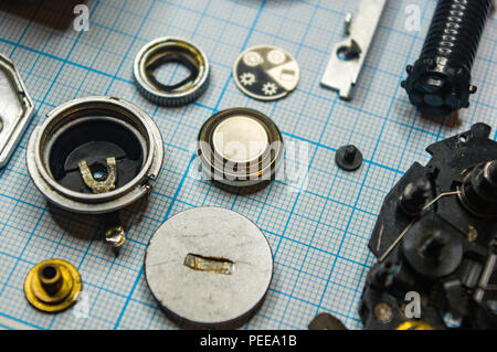 parts are completely disassembled old retro film SLR camera on graph paper, close-up Stock Photo