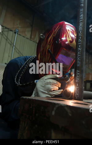 A Sailor assigned to USS Abraham Lincoln (CVN 72) performs welding at the Light Industrial Facility during the ship’s Refueling and Complex Overhaul at Newport News Shipbuilding. The Nimitz-class aircraft carrier undergoes extensive maintenance, upgrades electrical, piping, and structural systems, ensuring operational readiness and support for extended naval missions. Shipyard activities include inspection, fabrication, and repair to prepare the vessel for future deployments and sustained aviation operations. Stock Photo