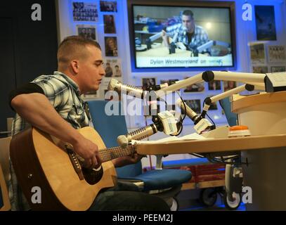 Airman 1st Class Dylan Westmoreland, 790th Quick Response Force, performs on a broadcast at the Children's Hospital Colorado in Aurora, Colo., Jan. 6, 2016. Westmoreland participated in various discussions with the staff and children throughout the day. (U.S. Air Force photo by Airman 1st Class Malcolm Mayfield) Stock Photo