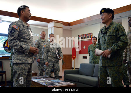 Col. Teo Wee Hong (right), chief of staff, 6th Division, Singapore army, speaks to Lt. Col. Wesley Tanji, executive officer, 298th Regiment, Regional Training Institute NCO Academy, Hawaii Army National Guard, during an inspection tour at the 298th Regiment's Multi-Functional Training Unit (MFTU) located at Bellows Air Force Station, Hawaii, on Jan. 21, 2016. Hong's visit to the MFTU was part of a greater tour of military facilities in Hawaii in conjunction with the 3rd Brigade Combat Team, 25th Infantry Division, Jan. 19-22. (Photo by Staff Sgt. Armando R. Limon, 3rd Brigade Combat Team, 25th Stock Photo