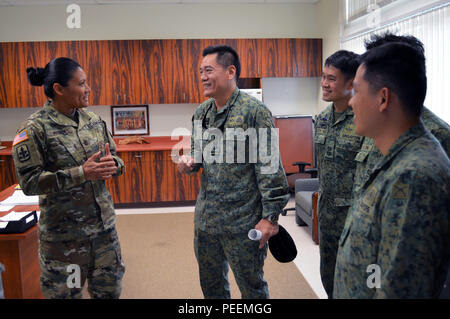 Col. Teo Wee Hong (center), chief of staff, 6th Division, Singapore army, speaks to Command Sgt. Maj. Belynn A. Watson, commandant, 298th Regiment, Regional Training Institute NCO Academy, Hawaii Army National Guard, during an inspection tour at the 298th Regiment's Multi-Functional Training Unit (MFTU) located at Bellows Air Force Station, Hawaii, on Jan. 21, 2016. Hong's visit to the MFTU was part of a greater tour of military facilities in Hawaii in conjunction with the 3rd Brigade Combat Team, 25th Infantry Division, Jan. 19-22. (Photo by Staff Sgt. Armando R. Limon, 3rd Brigade Combat Tea Stock Photo