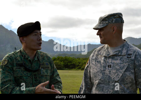 Col. Teo Wee Hong (left), chief of staff, 6th Division, Singapore army, speaks with Capt. Matt Potts, operations officer (S-3), 3rd Brigade Combat Team, 25th Infantry Division, on the 298th Regiment's Multi-Functional Training Unit (MFTU) facilities located at Bellows Air Force Station, Hawaii, on Jan. 21, 2016. The 3rd Brigade Combat Team, 25th Infantry Division, hosted the six officer delegation at Schofield Barracks, Hawaii, to discuss preparations for Tiger Balm 16 exercise slated to happen throughout Hawaii this summer. (Photo by Staff Sgt. Armando R. Limon, 3rd Brigade Combat Team, 25th  Stock Photo