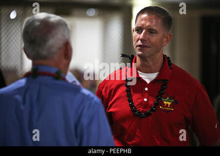 Retired Marine Lt. Col. Oliver L. North, now a military historian, television host with Fox News and San Antonio native, speaks with Maj. James Burke, the executive officer for Charlie Company, Wounded Warrior Battalion West-Detachment Hawaii, after a reception at The Officers’ Club aboard Marine Corps Base Hawaii, Aug. 8, 2015. Hosted by the Honolulu Navy League, the reception was held as a fundraiser for the Friends of Windward Wounded Warriors. Donations raised for the organization go toward trips, crisis response and readiness, as well as post-traumatic stress and transition support groups Stock Photo