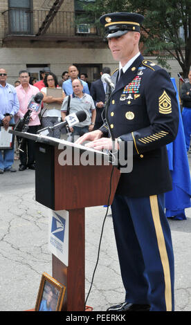 Command Sgt. Maj. Timothy A. Guden, Military District of Washington, speaking on behalf of Sgt. Maj. of the Army Daniel A. Dailey, addresses attendees of a post office rededication ceremony in honor of Cpl. Juan Mariel Alcantara Aug. 8, 2015, in New York City. Alcantara was killed by an improvised explosive device Aug. 6, 2007, while deployed to Iraq. Stock Photo