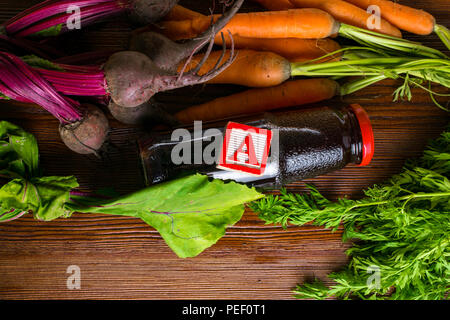 vitamin A in vegetable food, carrot, beet, pomegranate juice in wooden background. Detox Stock Photo