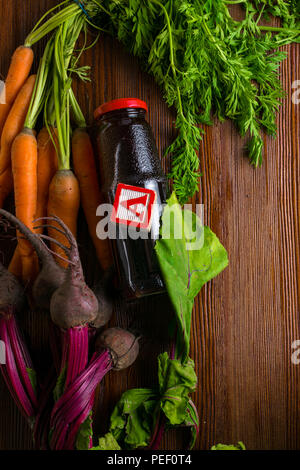 vitamin A in vegetable food, carrot, beet, pomegranate juice in wooden background. Detox Stock Photo