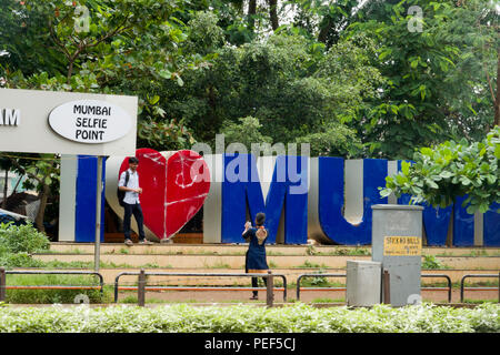 Indian couple taking photos at Mumbai Selfie Point in Juhu, Mumbai, India Stock Photo